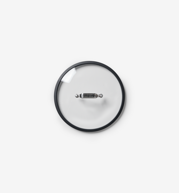 Glass pot lid with stainless steel handle and black silicone rim, top view