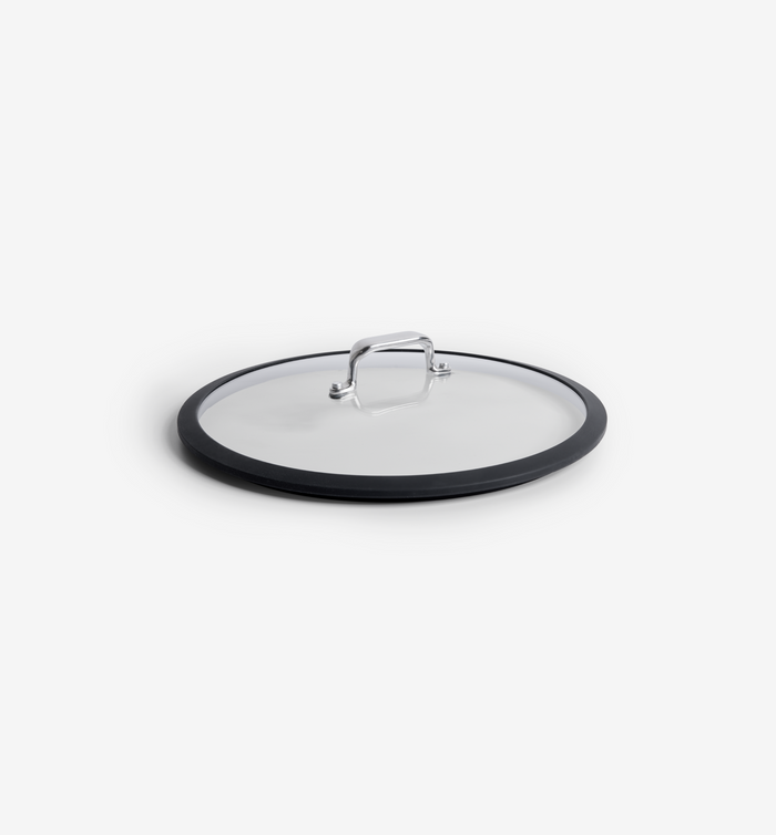 Glass pan lid with black silicone rim and stainless steel handle