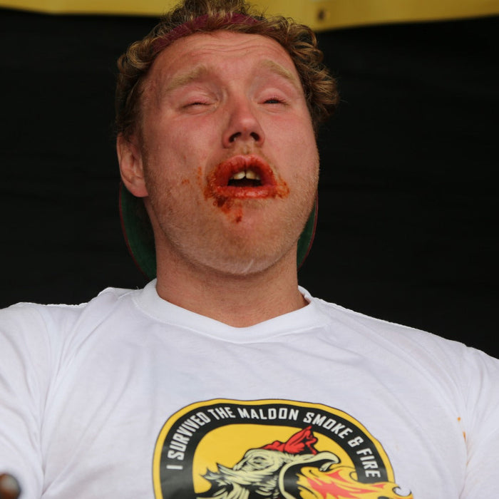 Man with spicy face after eating hot wings at a food festival, risk awareness