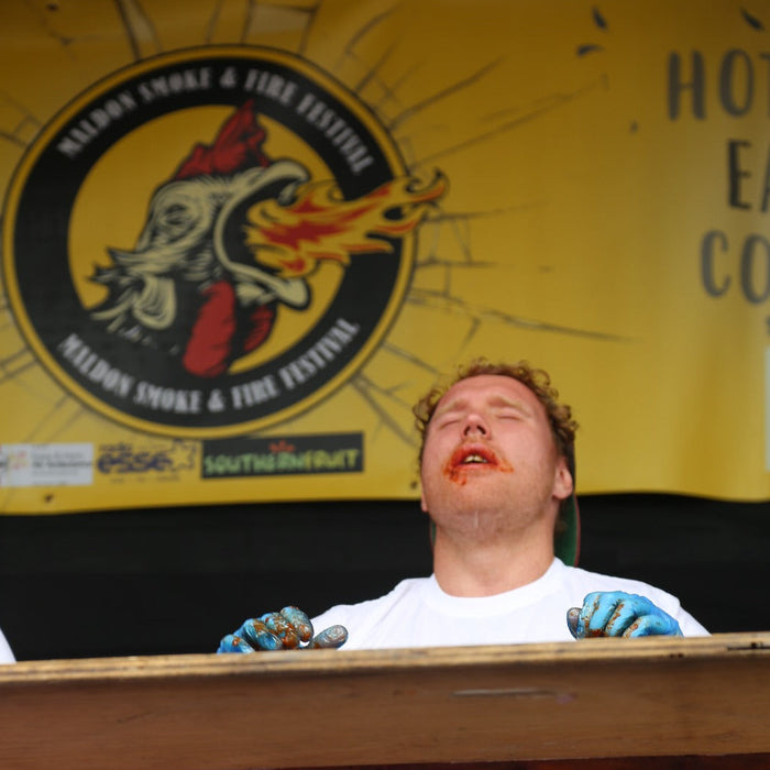 Man with spicy face after eating hot wings at a food festival, risk awareness