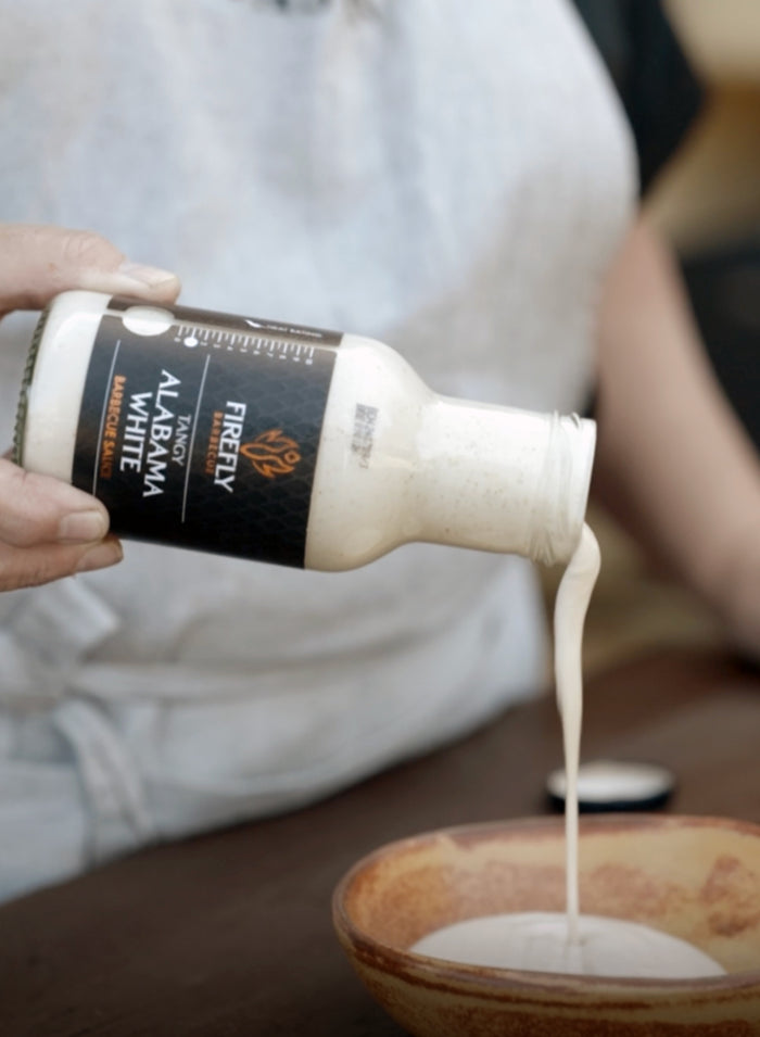 Grilled meat with Alabama White BBQ Sauce and sauce bottle