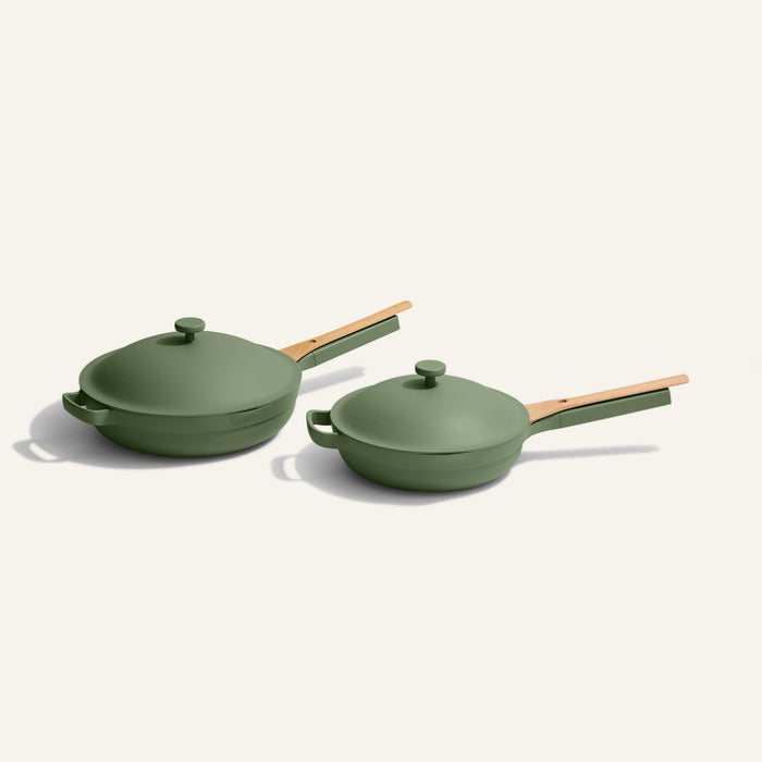 The Always Pan Duo features two green nonstick frying pans in different sizes with matching lids and wooden handles—versatile cookware displayed side by side on a light background, perfect for any kitchen.