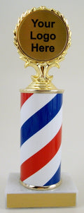 A trophy featuring a barber pole design with a column in the center, topped with a blank logo disc, on a white base with a blank engraving plate against a white background.