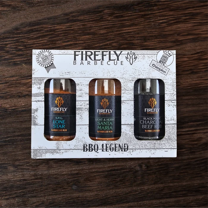 Close-up of BBQ spice bottles with black caps on wooden background