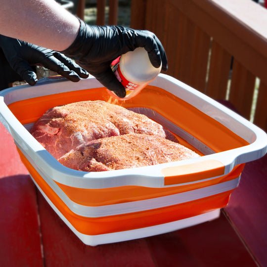 BBQ prep tub with cutting board and meat on outdoor deck for grilling prep