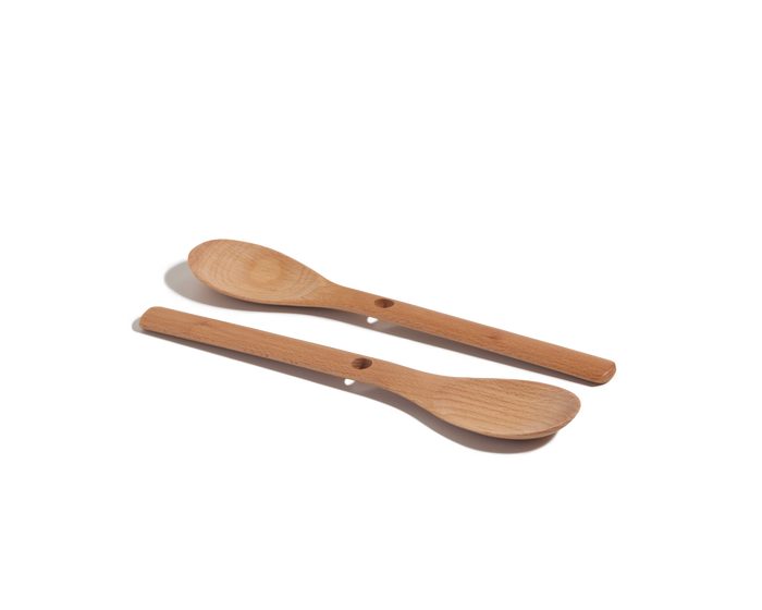 Two small Beechwood Spoons with round bowls and handle holes are shown on a white background—ideal as kitchen utensils.