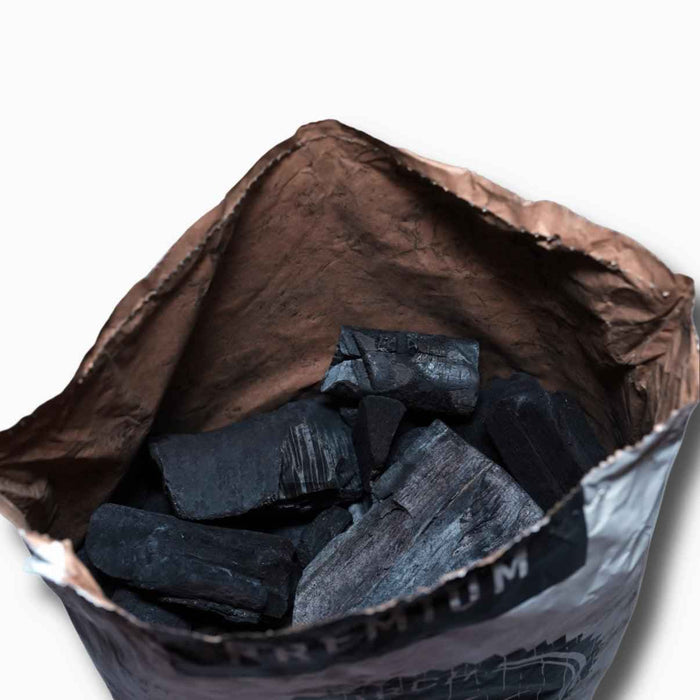 Close-up of charred wood with blackened surface, outdoor background