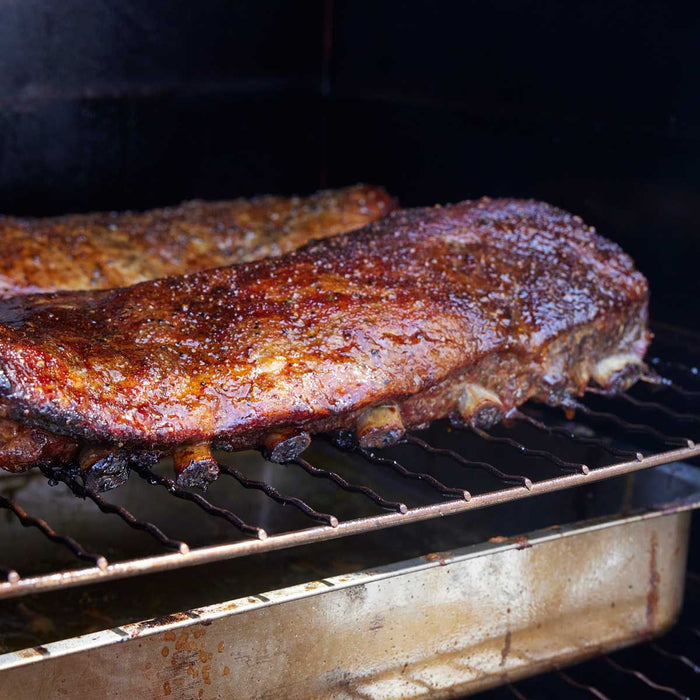 Cooking meat on a grill with a stainless steel Borniak smoker grate, high heat, outdoor barbecue