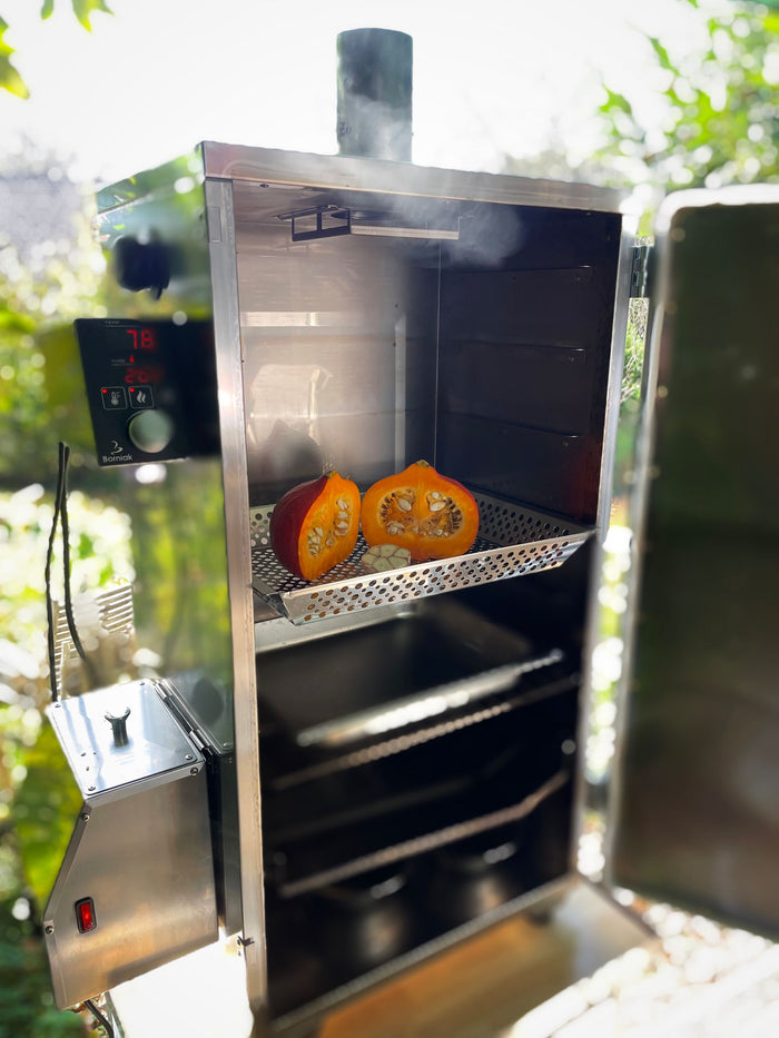 Outdoor grill smoker with stainless steel tray and smoked vegetables