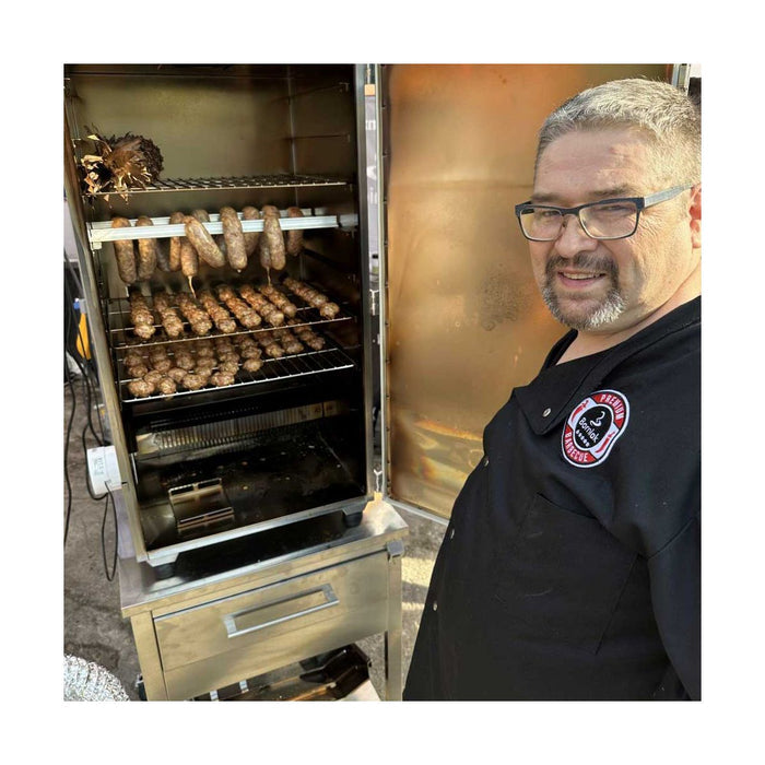 Man grilling sausages in commercial smoker with food dehydrator