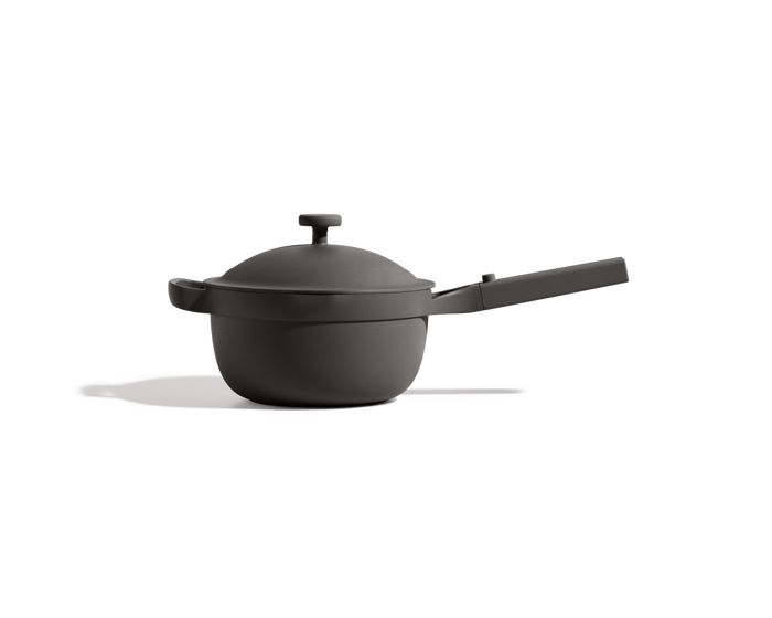 The Mini Perfect Pot 2.0, a matte black nonstick pot with a lid and long handle, is displayed from the side against a plain white background.