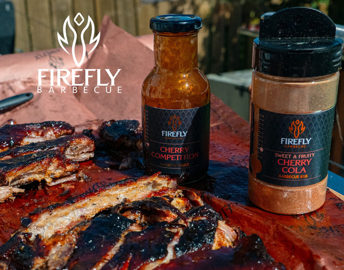 Cherry Cola BBQ Rub jar on kitchen counter with cooked meat