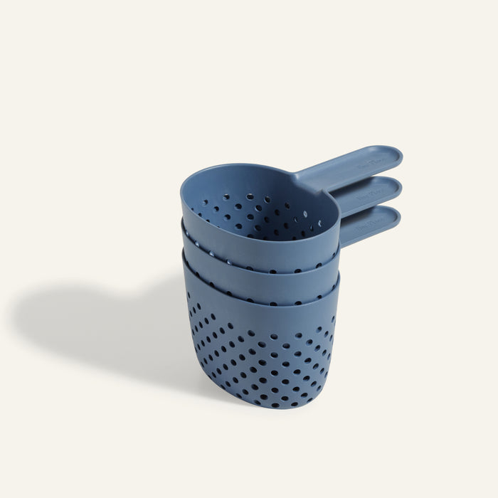 Three blue plastic Cooker Cups with perforated holes, stacked together on a light background—ideal for cooking three things at once and the perfect multi-purpose companion to your Perfect Pot.