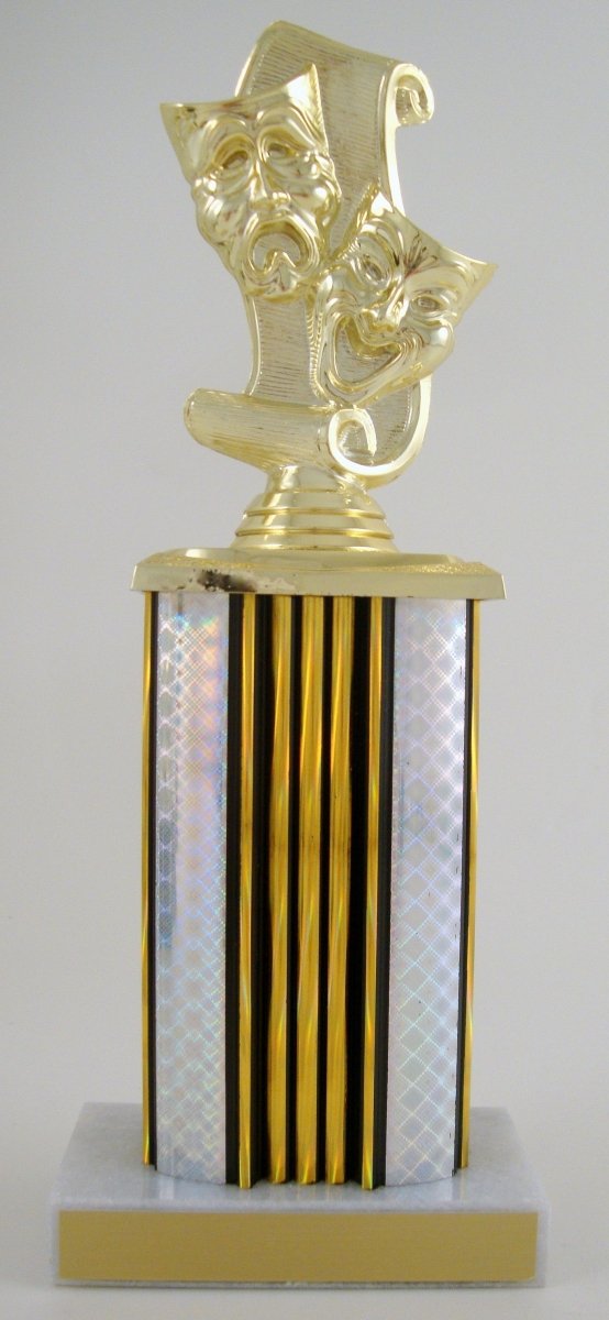 A gold-colored trophy featuring three classical theater masks (comedy, tragedy, and drama) on a scroll-like top, mounted on a striped gold and iridescent column over a white and gold base.