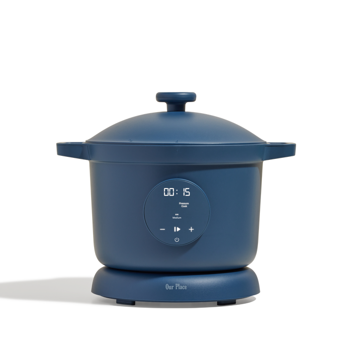 The Dream Cooker, an electric multicooker in blue with a digital display showing 00:15, touch controls, and 'Our Place' branding on the base, is featured against a plain white background.