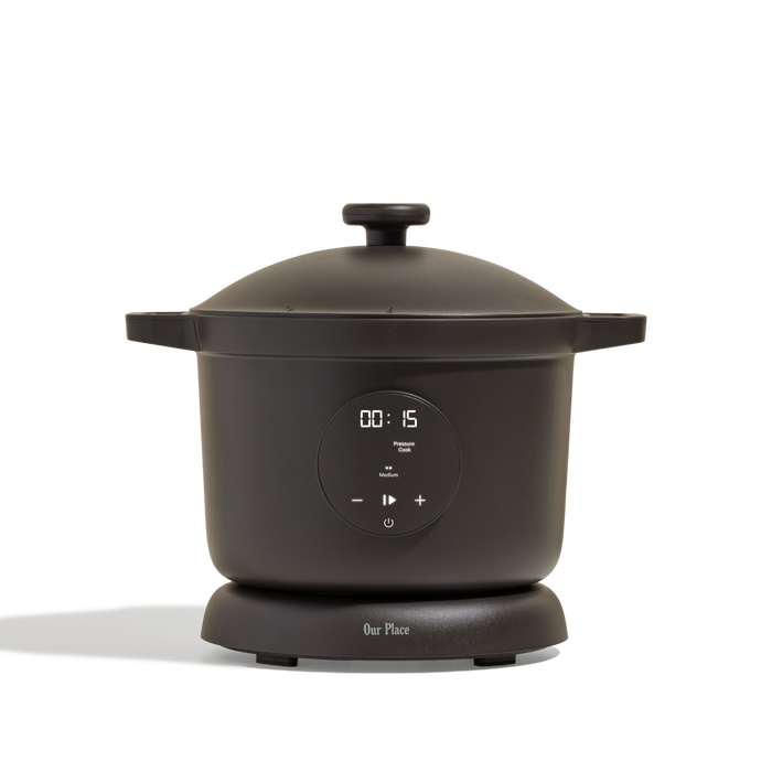 The Dream Cooker, a sleek black multicooker with digital display set to 15 minutes, rounded edges, two side handles, and a lid, sits on a white background—ideal for effortless cooking.