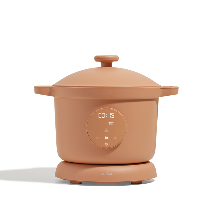 The Dream Cooker is a tan, stylish multicooker with a digital display and easy control buttons on the front, set on a matching base. Ideal for effortless cooking in any modern kitchen.
