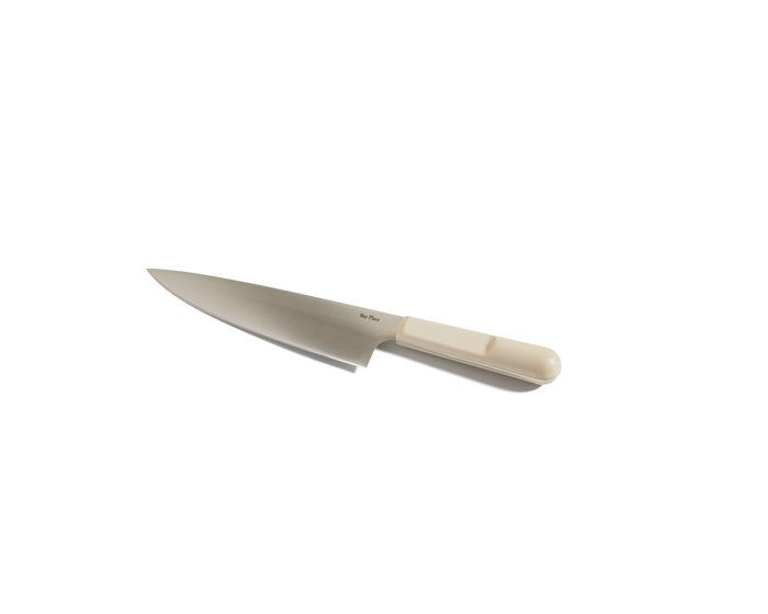 The Everyday Chef’s Knife, featuring a light-colored handle and crafted from German steel, is displayed on a plain white background.