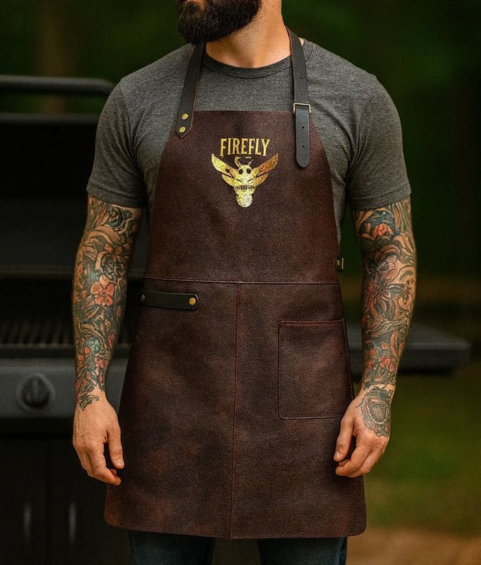 Man wearing leather BBQ apron with logo