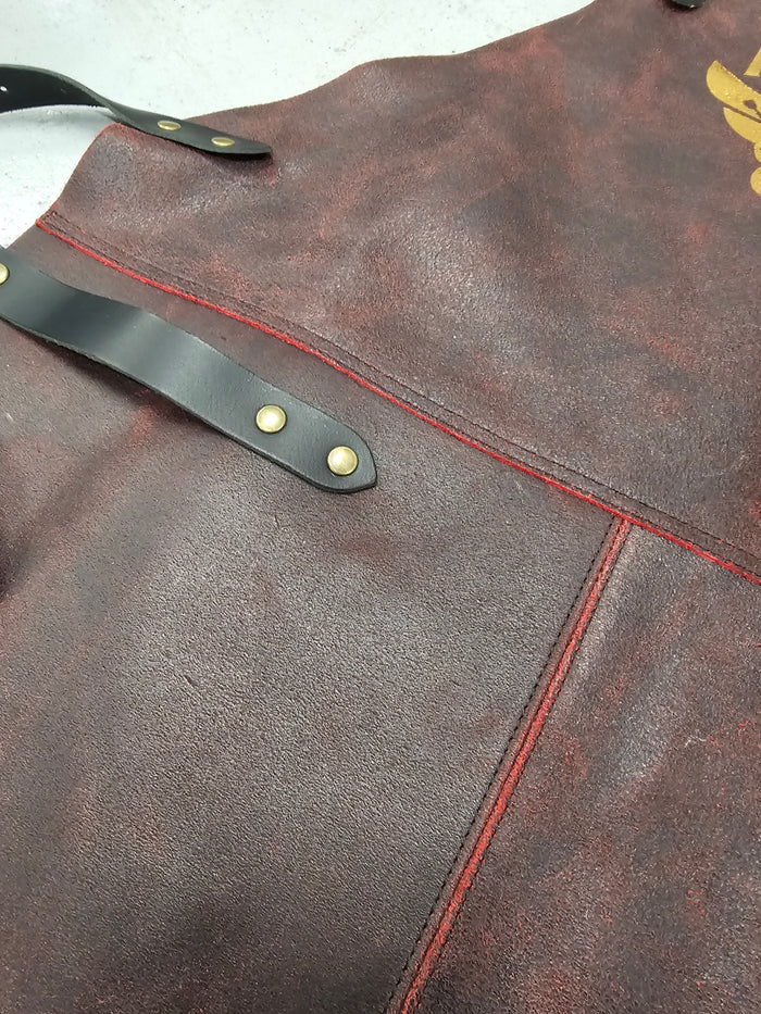 Close-up of leather BBQ apron with logo and red stitching