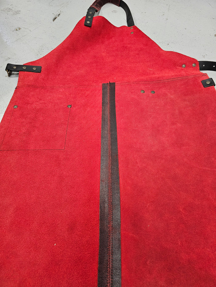 Red leather apron with black straps and zipper