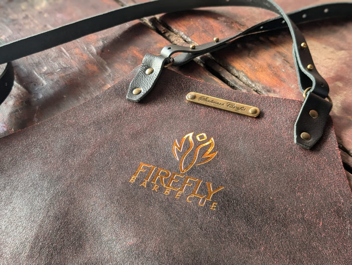 Close-up of leather apron with logo and adjustable strap