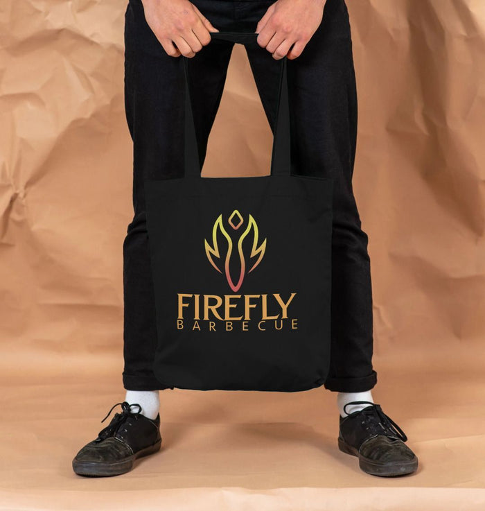 Firefly Barbeque Cotton Bag - Organic Tote held by man, showcasing sturdy handles and eye-catching flame design for versatile everyday use.