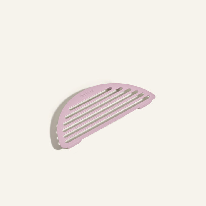 A pink, semi-circular slotted soap dish inspired by the sleek Fry Deck design is displayed on a plain, light-colored background.
