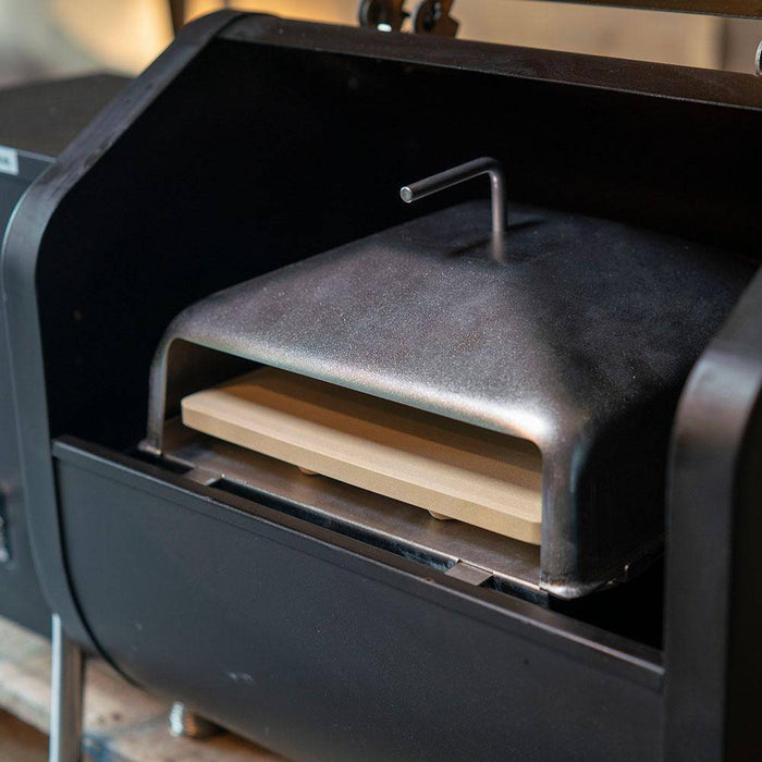 Wood-fired pizza oven with metal lid and handle