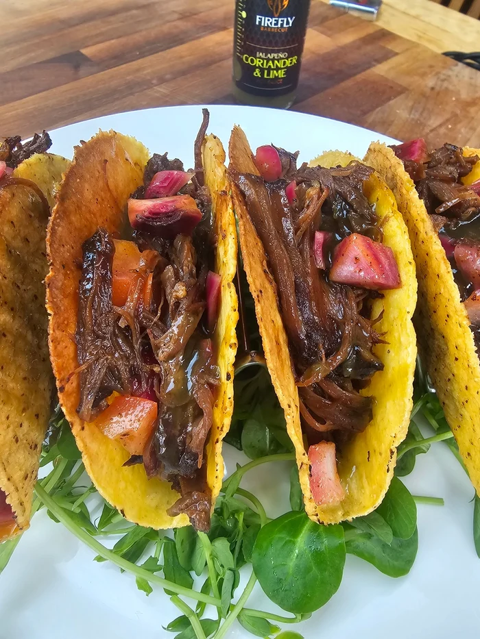 Hot sauce bottle with tacos and ingredients