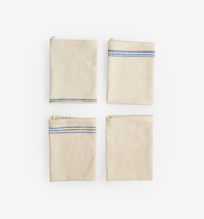 Set of four folded linen kitchen towels with blue stripe detail