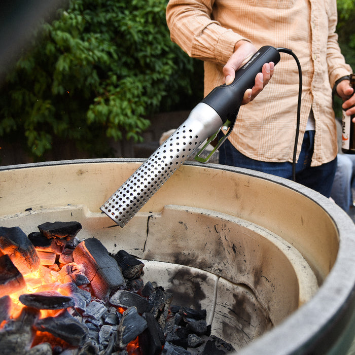 Person using electric firelighter to start a fire in a fire pit
