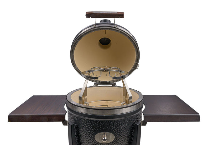 Monolith grill with open lid and side wooden tables for outdoor cooking
