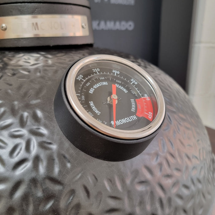 Close-up of Monolith BBQ thermometer dial on grill