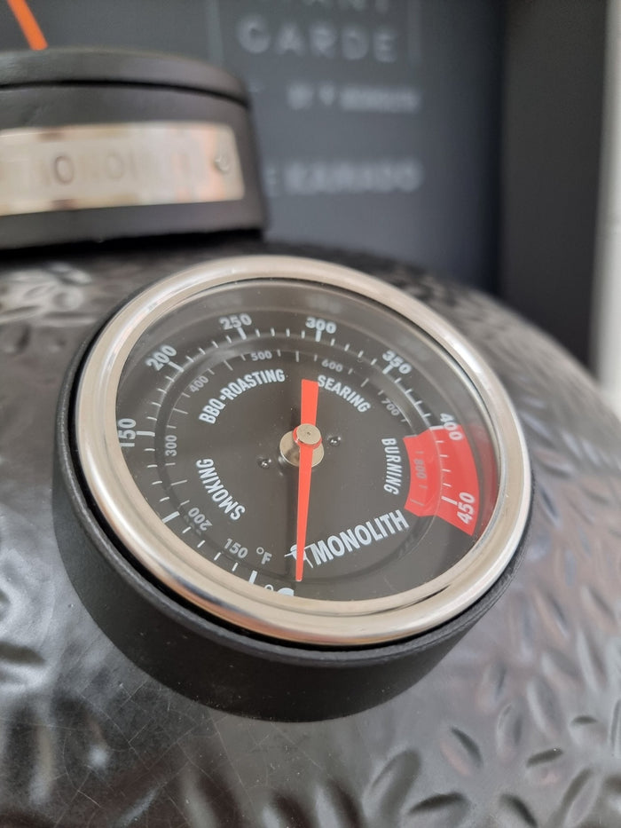 Detailed view of Monolith BBQ thermometer on grill surface