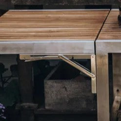 MONOLITH Hinges - Monolith Buggy Table | Side Table Set shown installed on a wooden outdoor grill table. Durable metal hinge supports side table extension.