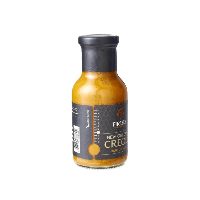 Side view of Firefly BBQ New Orleans Creole Sauce bottle with textured black label, highlighting premium packaging for retail shelves.
