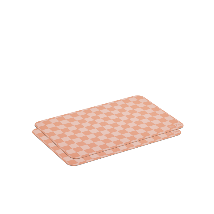 Two rectangular cutting boards in a peach and cream checkerboard pattern, stacked on a white background—ideal for pairing with Oven Mats for easy meal prep and cleanup.
