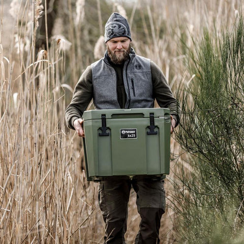 Outdoor man carrying Petromax 25L Cool Box in nature