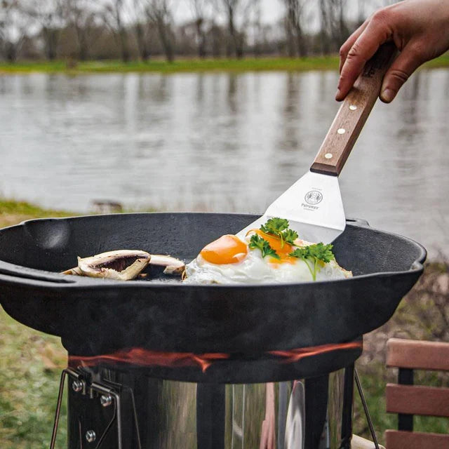 Petromax cast iron skillet with fried eggs and herbs outdoors