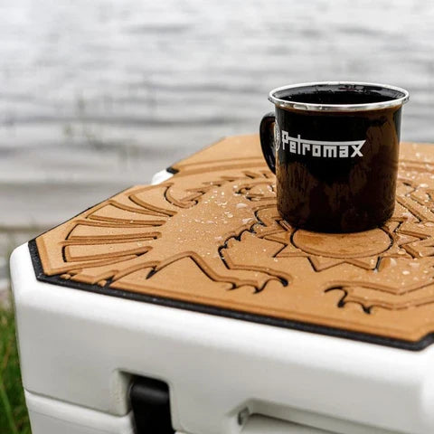 Close-up of Petromax dragon design adhesive pad on white cooler with mug