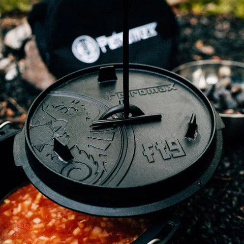 Petromax Dutch oven lid with lid lifter in outdoor cooking