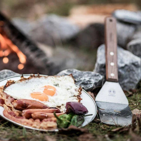 Petromax spatula on outdoor camping stove with cooked breakfast