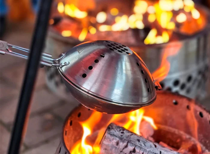 Popcorn popping over open fire with stainless steel popcorn maker