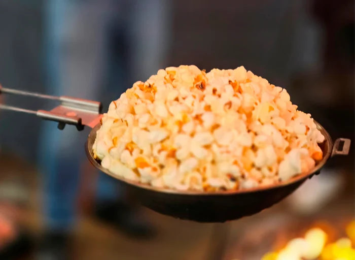 Freshly popped popcorn in a black skillet for outdoor cooking