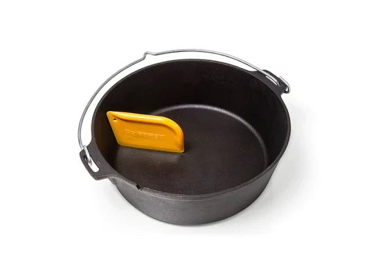 Petromax scraper for Dutch ovens, orange cleaning tool with handle for cast iron cookware in a black Dutch oven