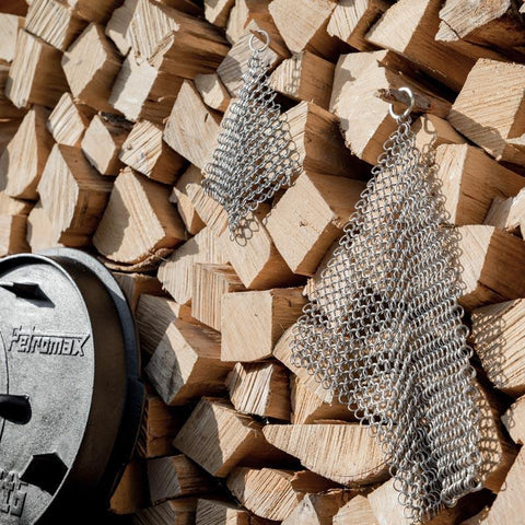 Chain mail cleaner hanging on firewood stack