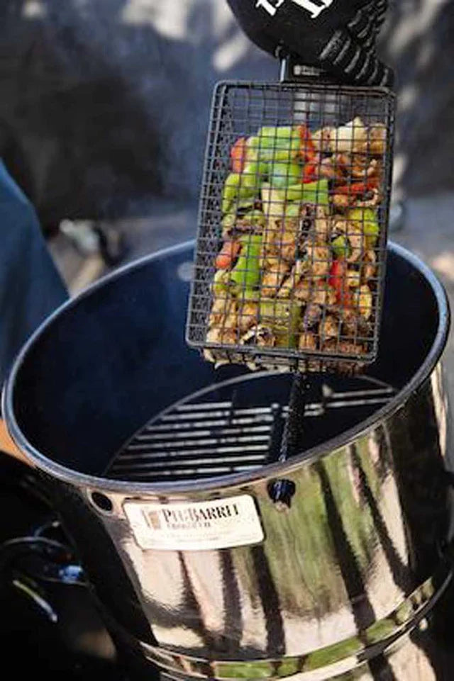 Pit Barrel All-Purpose Basket Hanger - FireFly Barbecue in use, filled with chopped vegetables over a Pit Barrel Cooker for outdoor grilling.