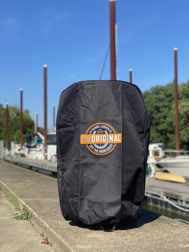 Pit Barrel Custom Fit Cover - FireFly Barbecue shown outdoors by a marina, showcasing durable weather-resistant material for Pit Barrel grill protection.