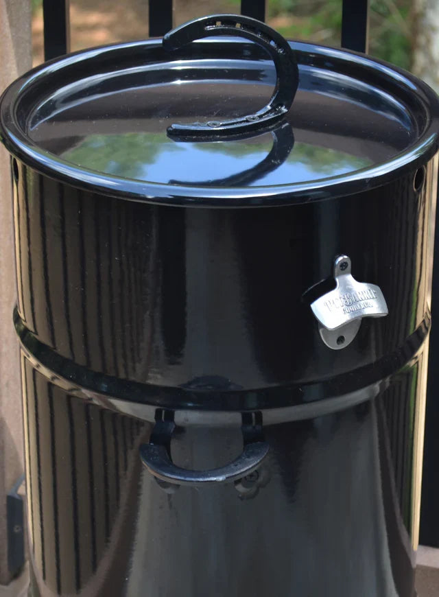 Black outdoor grill with Pit Barrel bottle opener on lid